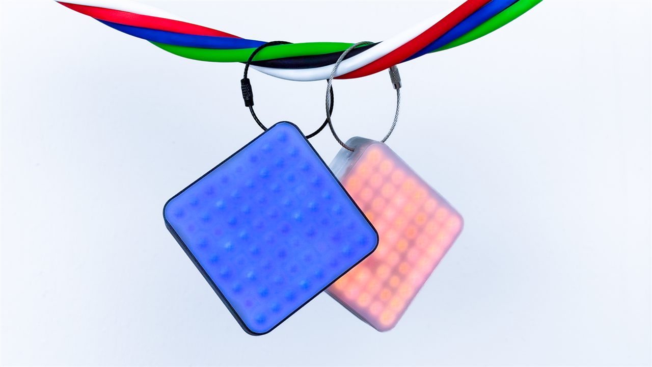 Two illuminated LEDS GO 8 editions suspended among coloured cables